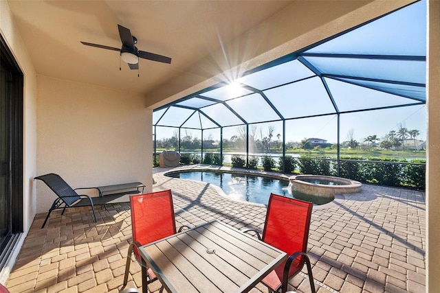 view of pool with a pool with connected hot tub, glass enclosure, a patio area, and ceiling fan