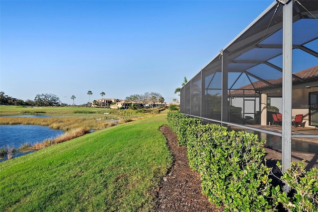 view of yard with a water view and a lanai