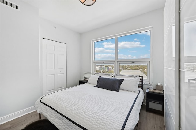 bedroom featuring dark wood-style floors, visible vents, and baseboards