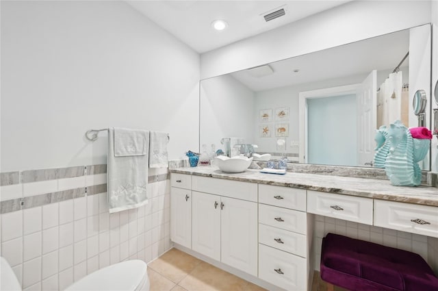 full bathroom with visible vents, toilet, tile patterned floors, vanity, and tile walls