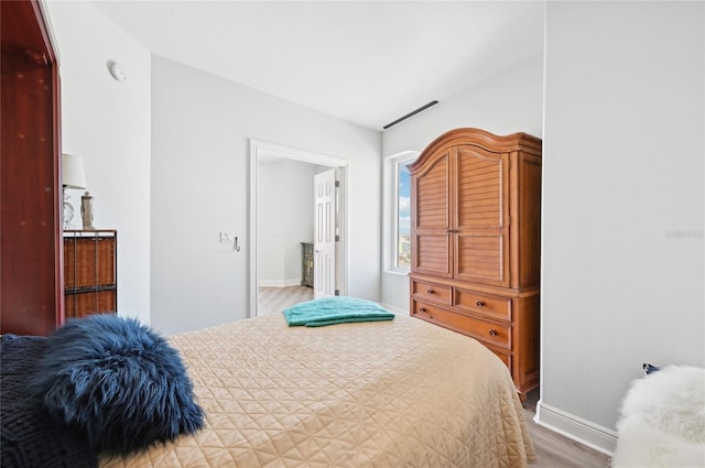 bedroom with light wood-type flooring and baseboards