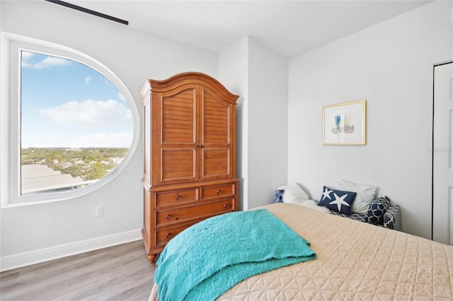 bedroom with baseboards and wood finished floors