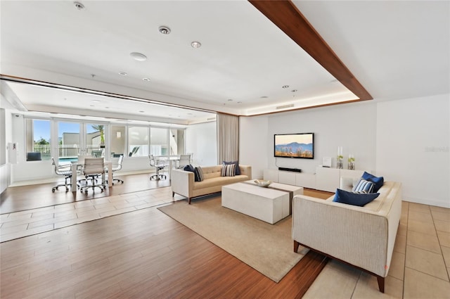 living room with a raised ceiling and wood finished floors