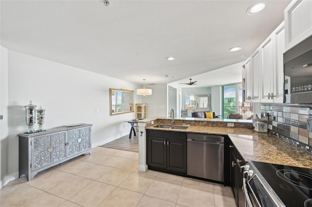 kitchen featuring electric stove, a peninsula, stainless steel dishwasher, black microwave, and a sink