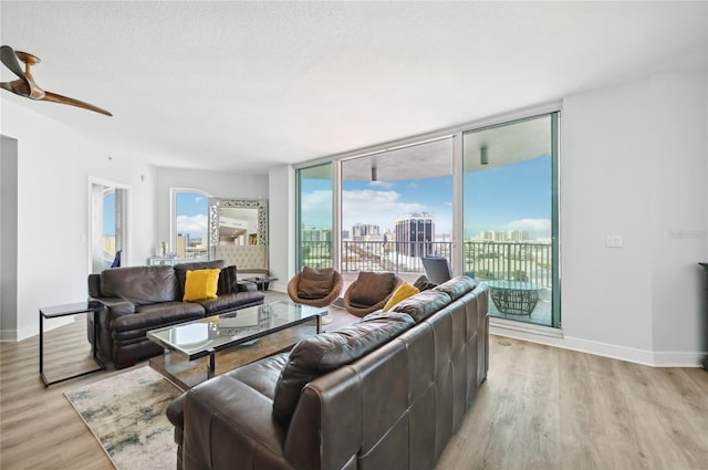 living area with a view of city, light wood-style flooring, and baseboards