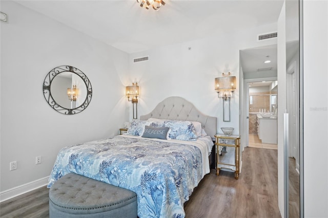 bedroom featuring baseboards, visible vents, and wood finished floors