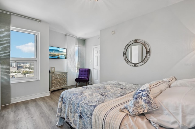 bedroom with baseboards and wood finished floors