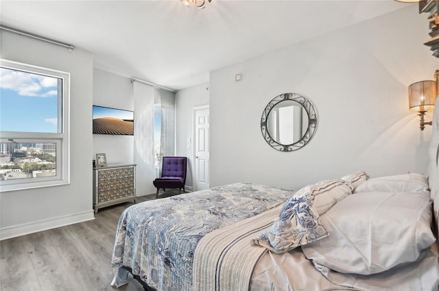 bedroom with baseboards and wood finished floors