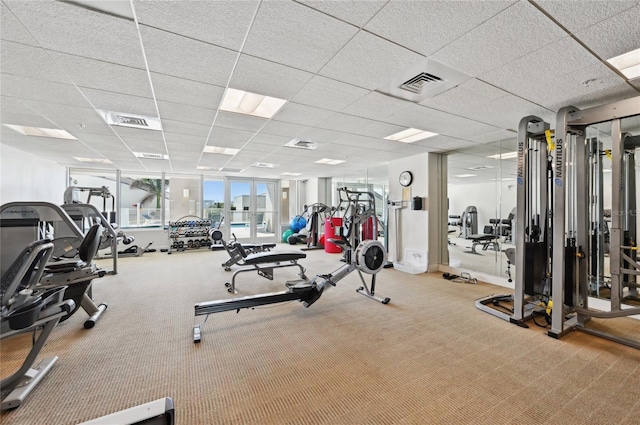 gym with a paneled ceiling, carpet flooring, and visible vents