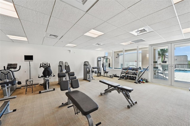 exercise room with carpet, visible vents, a drop ceiling, and french doors