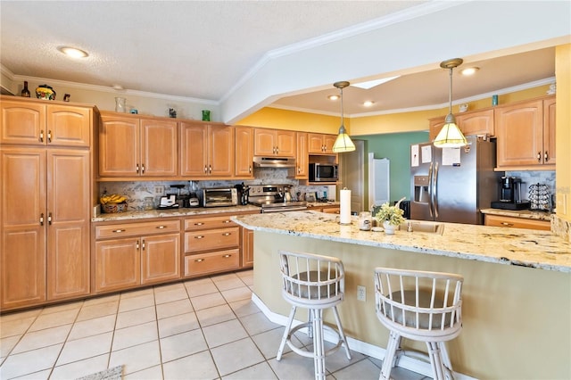 kitchen featuring light stone counters, tasteful backsplash, hanging light fixtures, a kitchen breakfast bar, and stainless steel appliances