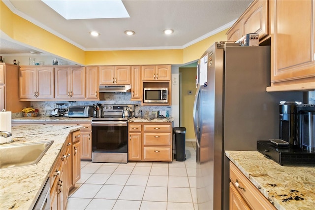 kitchen featuring ornamental molding, appliances with stainless steel finishes, light brown cabinets, and a skylight