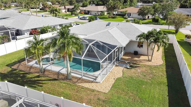 view of pool with a lanai, a patio area, and a lawn