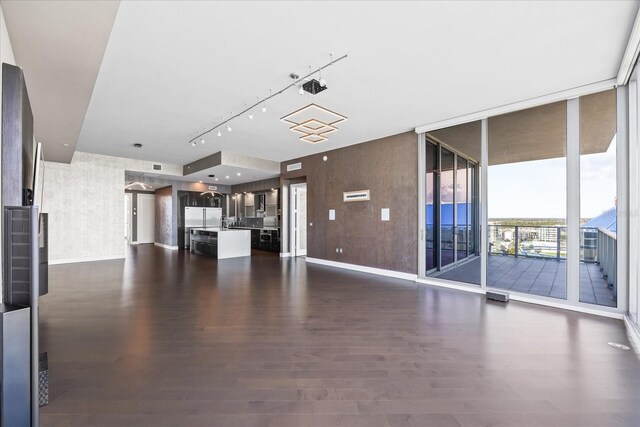 1155 N Gulfstream Ave Unit 1709, Sarasota, FL 34236 - unfurnished living room featuring rail lighting, dark wood finished floors, and a wall of windows