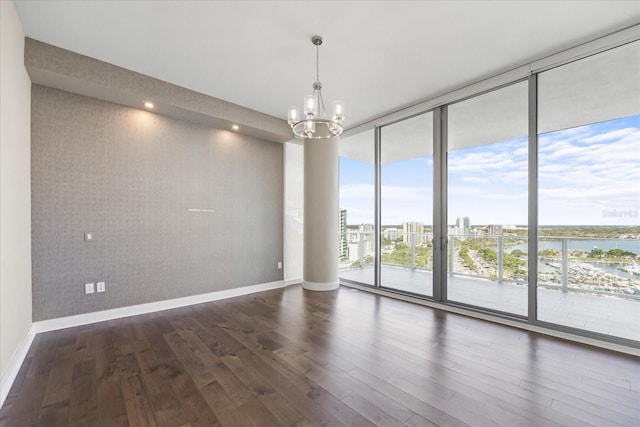 1155 N Gulfstream Ave Unit 1709, Sarasota, FL 34236 - spare room with a wall of windows, dark wood-style flooring, a chandelier, and a water view