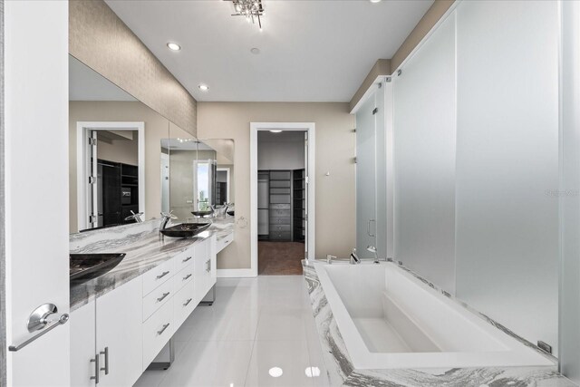 1155 N Gulfstream Ave Unit 1709, Sarasota, FL 34236 - bathroom with double vanity, a spacious closet, a bath, tile patterned flooring, and recessed lighting