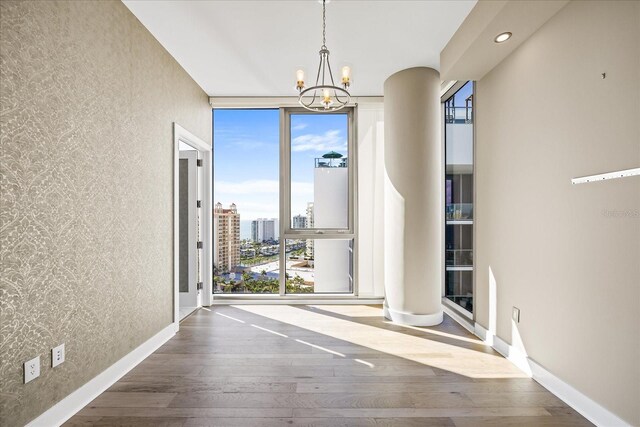 1155 N Gulfstream Ave Unit 1709, Sarasota, FL 34236 - unfurnished room featuring expansive windows, plenty of natural light, a chandelier, wood-type flooring, and a textured wall