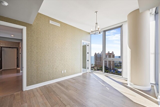 1155 N Gulfstream Ave Unit 1709, Sarasota, FL 34236 - unfurnished dining area featuring wallpapered walls, plenty of natural light, wood finished floors, and a chandelier
