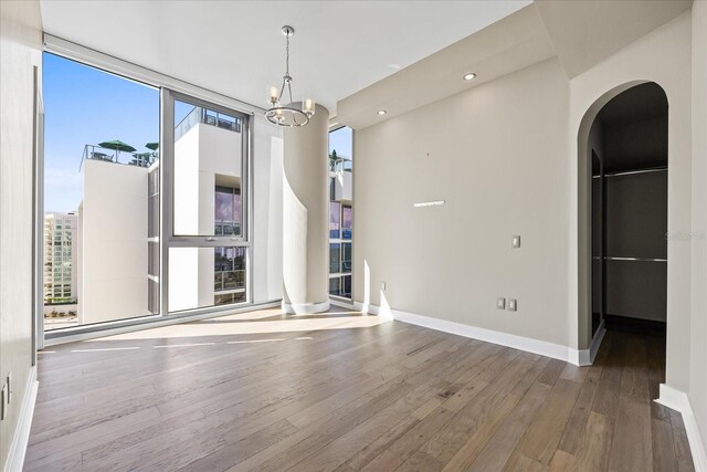 1155 N Gulfstream Ave Unit 1709, Sarasota, FL 34236 - empty room featuring plenty of natural light, wood finished floors, arched walkways, a chandelier, and recessed lighting