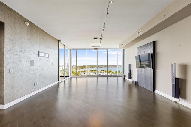 1155 N Gulfstream Ave Unit 1709, Sarasota, FL 34236 - unfurnished living room with floor to ceiling windows, track lighting, dark wood-type flooring, and an accent wall