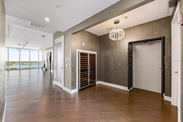 1155 N Gulfstream Ave Unit 1709, Sarasota, FL 34236 - spare room featuring a wall of windows, wood finished floors, a water view, wine cooler, and a chandelier