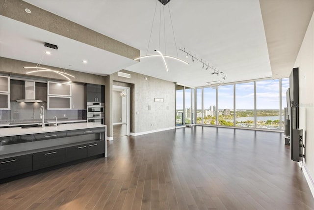 1155 N Gulfstream Ave Unit 1709, Sarasota, FL 34236 - kitchen featuring wall chimney range hood, open floor plan, a wall of windows, modern cabinets, and light countertops