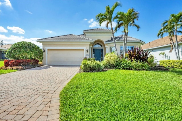 view of front of home featuring decorative driveway, an attached garage, stucco siding, and a front yard