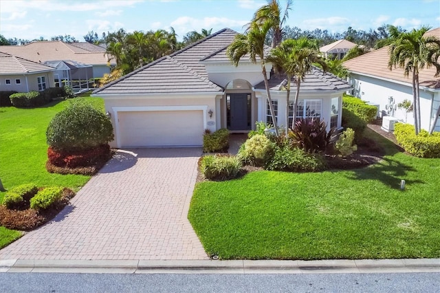 view of front of house featuring an attached garage, a tiled roof, decorative driveway, stucco siding, and a front yard