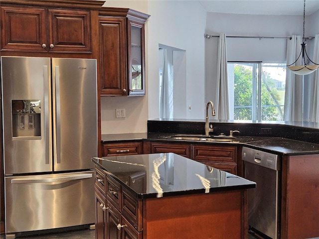 kitchen featuring glass insert cabinets, dark stone countertops, appliances with stainless steel finishes, and a sink