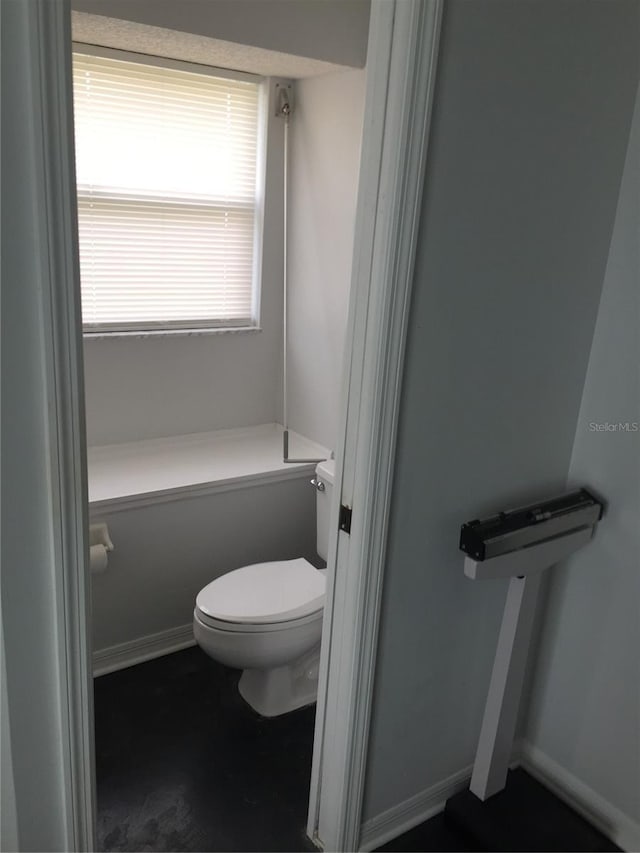 bathroom with baseboards and toilet