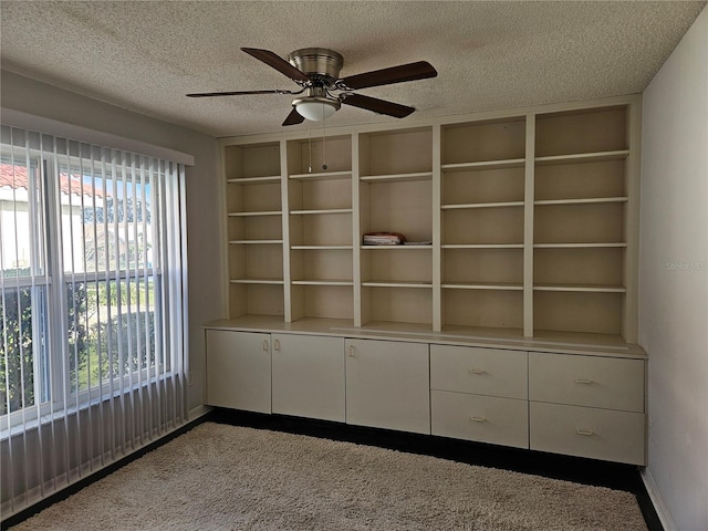 interior space with a textured ceiling and ceiling fan