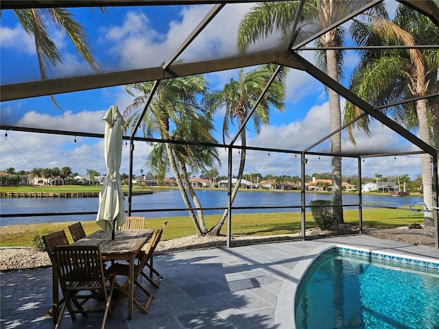 outdoor pool featuring a water view, a patio area, and a lanai