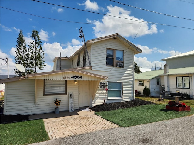 view of property with cooling unit and a front lawn