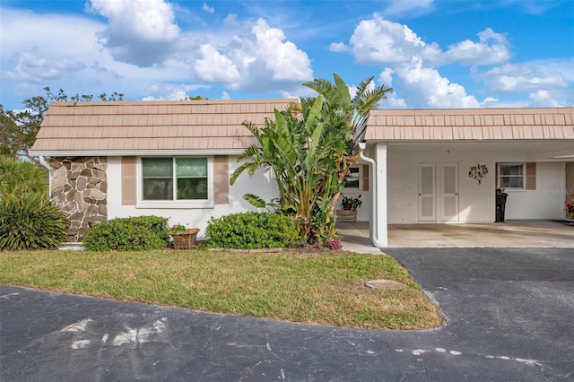 ranch-style home with a front lawn and a carport