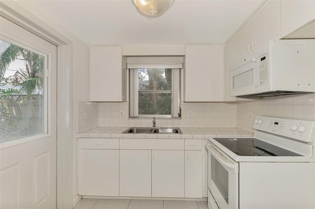 kitchen featuring white appliances, a healthy amount of sunlight, white cabinetry, and sink