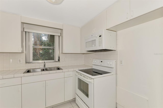 kitchen with white appliances, white cabinetry, sink, and tasteful backsplash