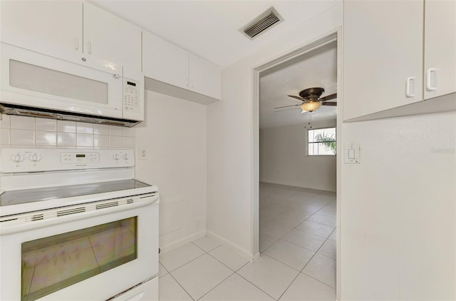 kitchen with white appliances, light tile patterned floors, ceiling fan, white cabinets, and tasteful backsplash