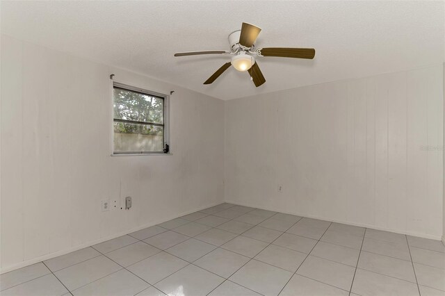 tiled empty room featuring a textured ceiling and ceiling fan