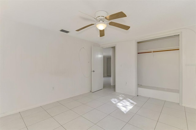 unfurnished bedroom with ceiling fan, light tile patterned floors, and a closet