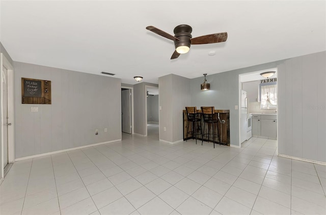 tiled empty room featuring ceiling fan