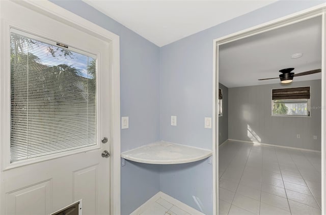 bathroom with ceiling fan and tile patterned flooring