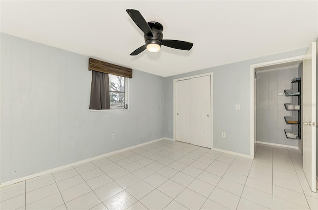 unfurnished bedroom featuring ceiling fan, light tile patterned flooring, and a closet