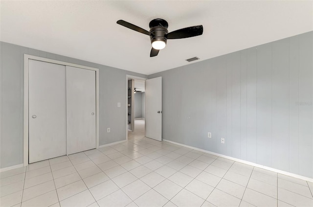 unfurnished bedroom featuring a closet, ceiling fan, and light tile patterned floors