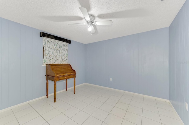 unfurnished room featuring ceiling fan, light tile patterned floors, and a textured ceiling