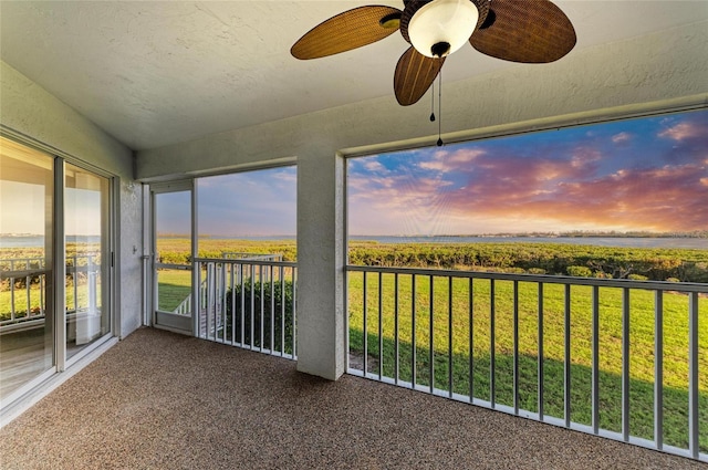 unfurnished sunroom featuring ceiling fan