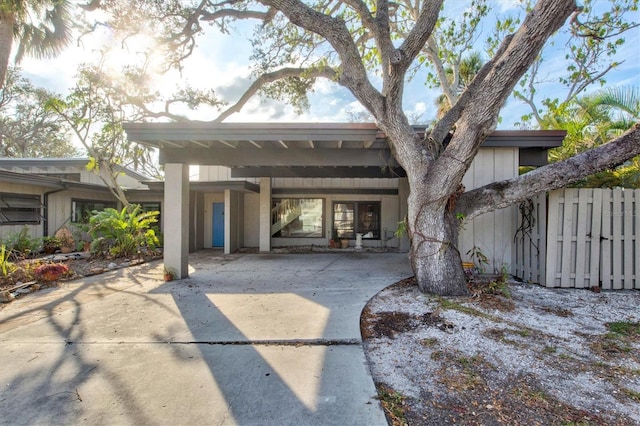 view of front facade with an attached carport and fence