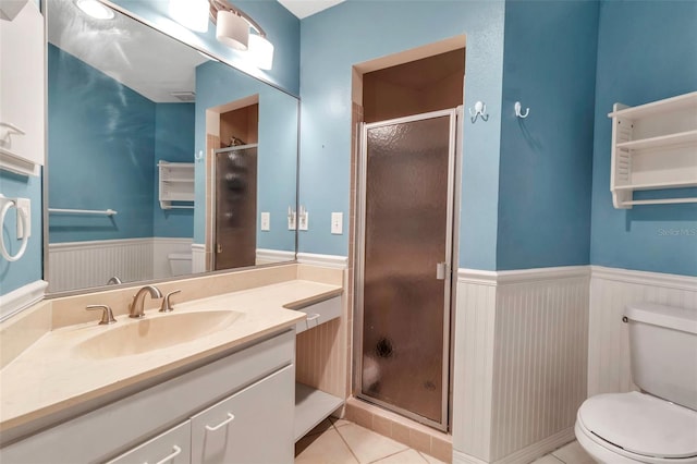 bathroom featuring tile patterned floors, toilet, a shower with shower door, and vanity