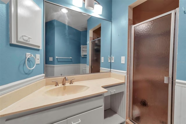 bathroom with a shower with door and vanity