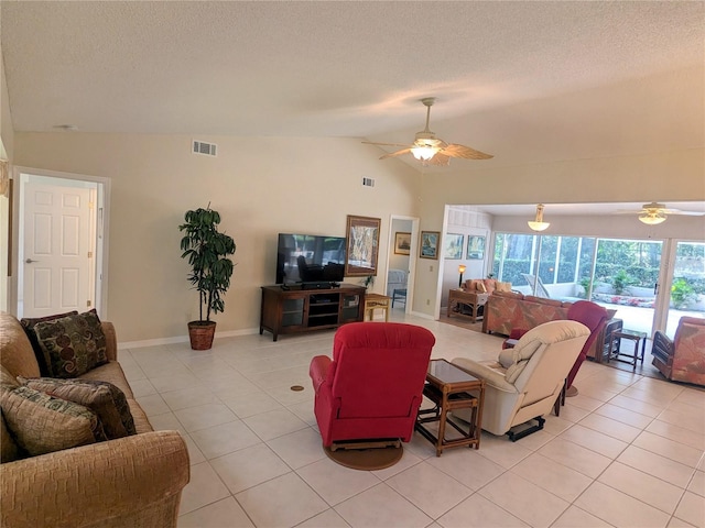 living room featuring lofted ceiling, light tile patterned floors, and a textured ceiling