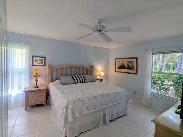 bedroom featuring ceiling fan, light tile patterned flooring, and multiple windows